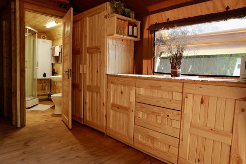 a bathroom with wooden cabinets and a window and a toilet at Глемпінг Шатро in Ulʼyaniki