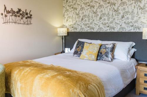 a bedroom with a white bed with a gold blanket at The Haughmond in Shrewsbury