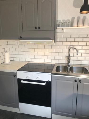 a kitchen with a sink and a stove and a sink at Mormors vrå in Mora