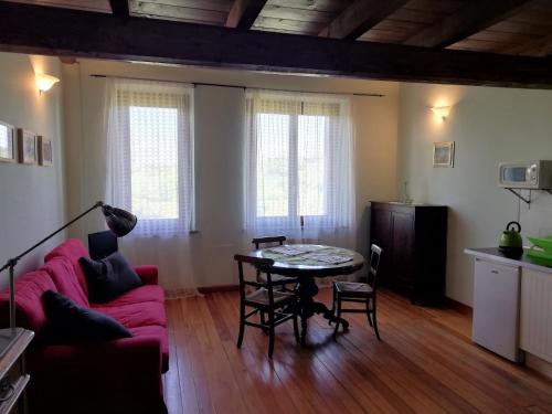 a living room with a pink couch and a table at Country House Cascina Orto in Pasturana