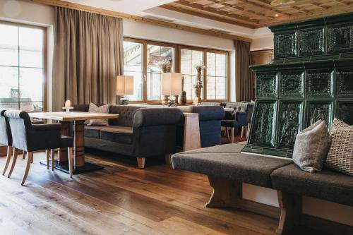 a living room with couches and a table and chairs at Hotel Wagnerhof in Pertisau