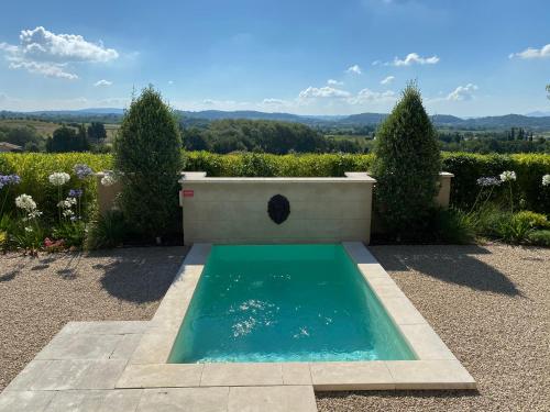 une piscine au milieu d'un jardin dans l'établissement Le Mazet d'Emilia avec jardin et piscine privés, à Cucuron