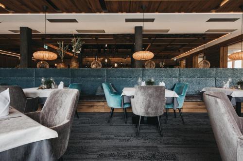 ein Restaurant mit weißen Tischen und blauen Stühlen in der Unterkunft Hotel Wagnerhof in Pertisau