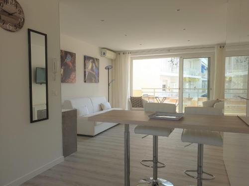 - un salon avec une table, des chaises et une horloge dans l'établissement STUDIO LES ALGUES, à Cannes