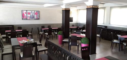 uma sala de jantar com mesas e cadeiras num restaurante em Hôtel Relais Ras El Maa em Ifrane