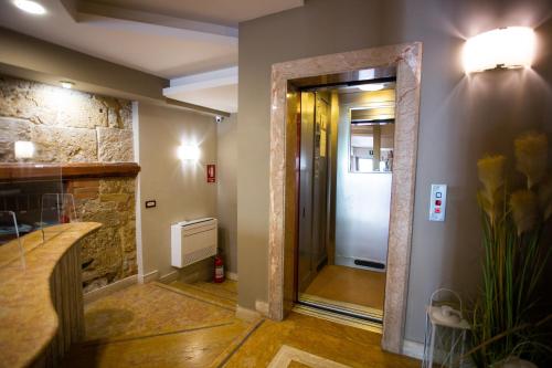a hallway with a door and a stone wall at Hotel Posta in Palermo