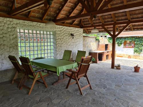 een groene tafel en stoelen op een patio bij Tündérfátyol Vendégház in Tiszafüred