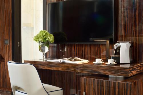 a desk with a television and a white chair at Le Boutique Hotel in Rome