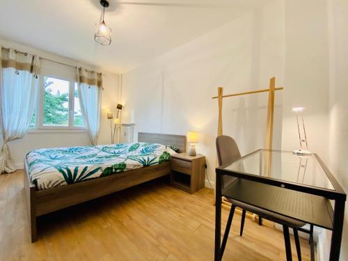 een slaapkamer met een bed en een glazen tafel bij Grand appartement plein centre proche bus et gare in Valence