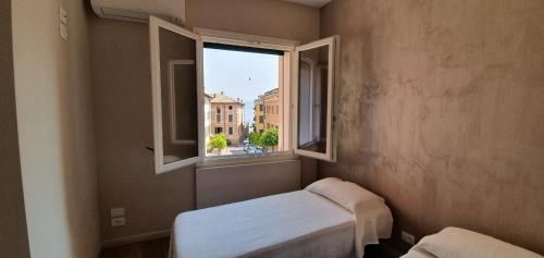 ガルニャーノにあるLa Casa di Annaの窓と白いベンチ付きの小さな客室です。