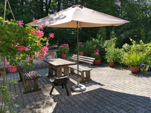 mesa de picnic con sombrilla y 2 bancos en Accommodation Destina, LAKE BOHINJ, en Bohinj