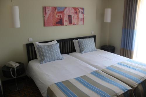 a bedroom with a bed with two pillows on it at Hotel Ordem De Santiago in Alcácer do Sal