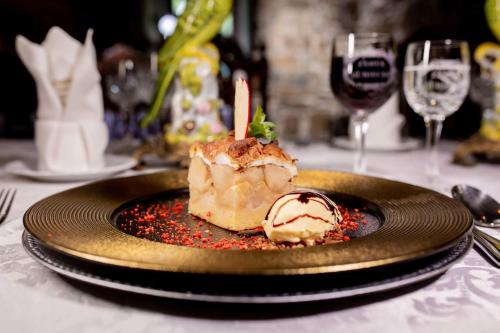 a plate with a dessert on a table with wine glasses at Zamek Dubiecko in Dubiecko