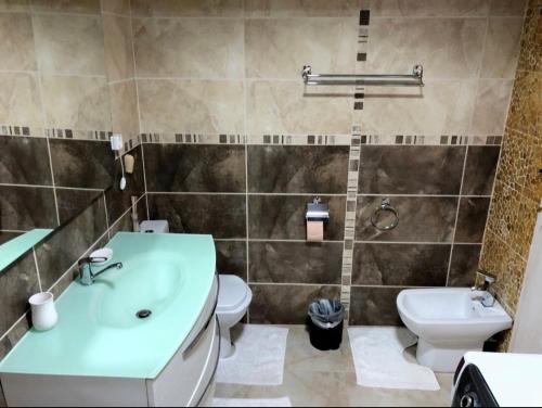 łazienka z umywalką, toaletą i wanną w obiekcie Bella Casa Apartments w Fogaraszu