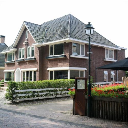 una casa de ladrillo con una luz de la calle delante de ella en De Juffer van Batinghe en Dwingeloo