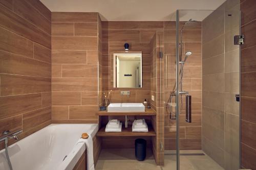 a bathroom with a tub and a sink and a shower at Boutique Hotel Beekhuizen in Velp