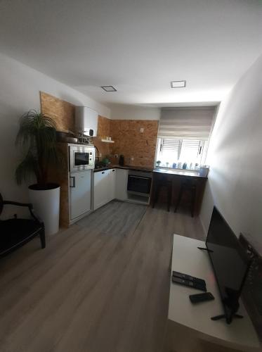 a living room with a kitchen with white appliances at APTORRE in Torre de Moncorvo