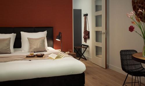 a bedroom with a bed with a book and two donuts on it at Boutique Hotel Beekhuizen in Velp