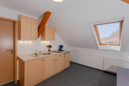 an attic kitchen with a sink and a window at Sportpark Rabenberg in Breitenbrunn