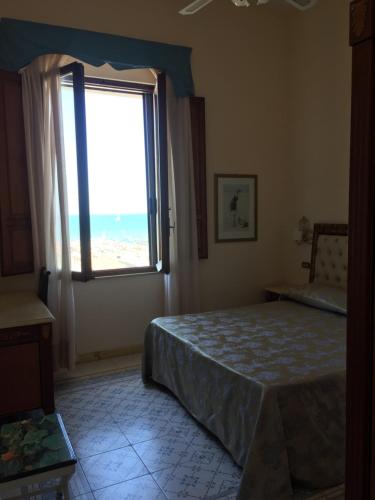a bedroom with a bed and a large window at Villa Tina Hotel in Viareggio