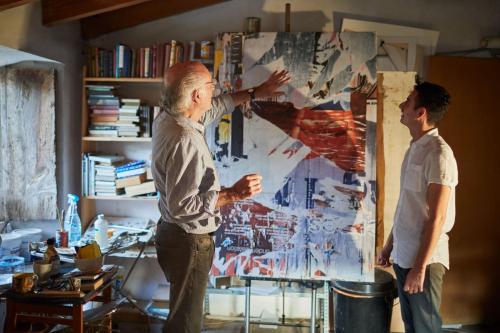 two men standing in a room with a painting at La Residencia, A Belmond Hotel, Mallorca in Deia