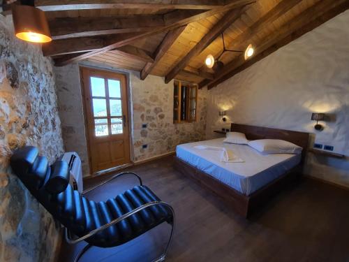 a bedroom with a bed and a chair in a room at Roots Dhermi in Dhërmi
