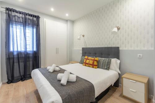 1 dormitorio con 1 cama y 2 toallas blancas en dobohomes - Oña en Madrid