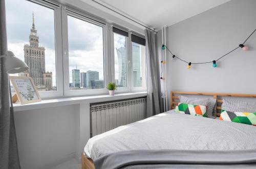 a bedroom with a bed with a view of the city at Bagno Cozy Studio II in Warsaw