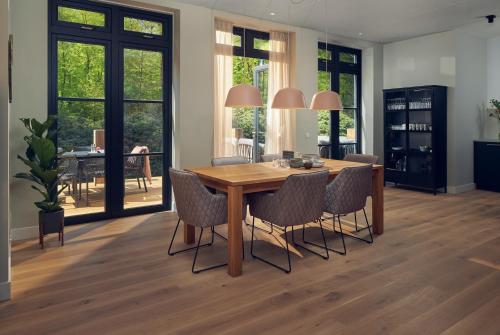 a dining room with a wooden table and chairs at Boutique Hotel Beekhuizen in Velp