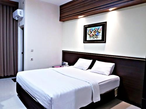 Hotel Setrasari Bandung في باندونغ: غرفة نوم بسرير كبير في غرفة