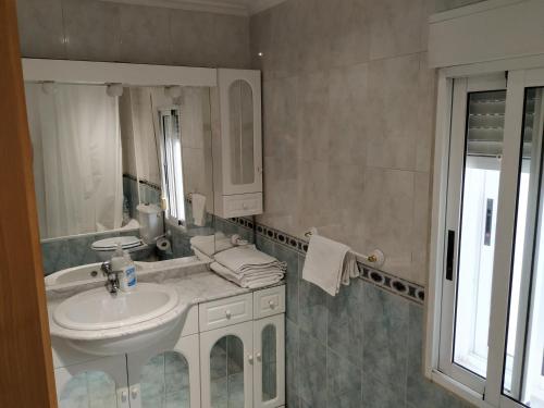 a white bathroom with a sink and a mirror at Apartamento CUATTRO vut 47-169 wifi in Valladolid