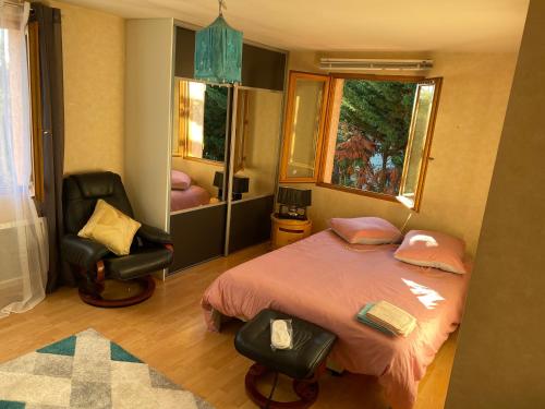 um quarto com uma cama, uma cadeira e uma janela em MAISON LOFT avec beaucoup de charme em Muret