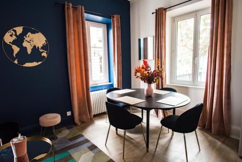 Théâtre Sinne Luxury Apartement في ميلوز: غرفة طعام مع طاولة وكراسي