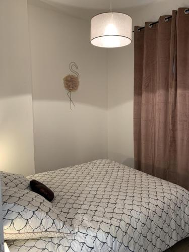a bedroom with a bed and a lamp and curtains at Théâtre Sinne Luxury Apartement in Mulhouse