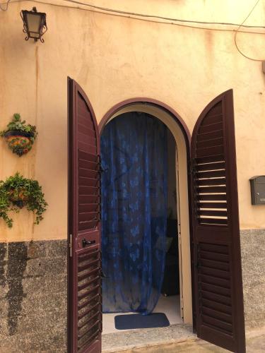 an entrance to a building with two open doors at the goat on the beach in Scilla