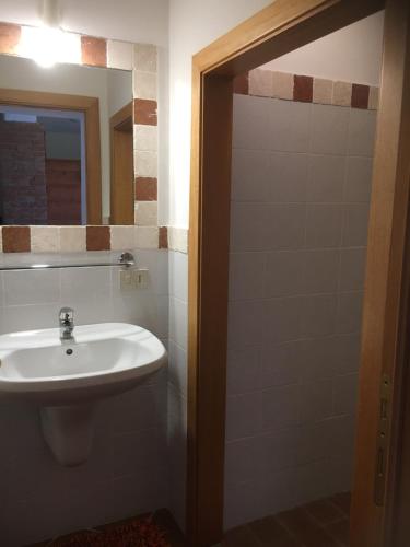 ein Bad mit einem Waschbecken und einem Spiegel in der Unterkunft Agriturismo Il Poggio in Casale Marittimo