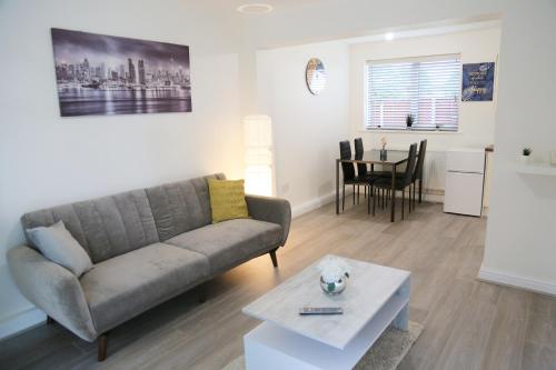 a living room with a couch and a table at Gorgeous ground floor apartment + free parking in Manchester