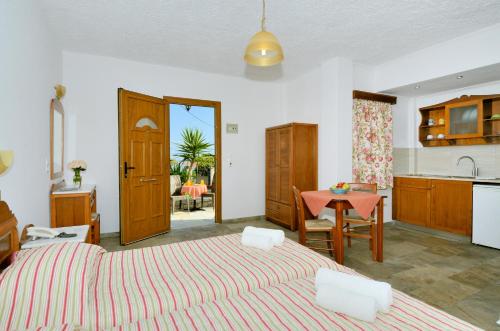 sypialnia z 2 łóżkami i stołem oraz kuchnia w obiekcie Agrilionas Hotel w mieście Marathokampos