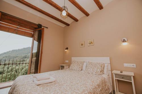 Un dormitorio con una cama y una ventana grande. en Casa Etxalde, en Camprodon