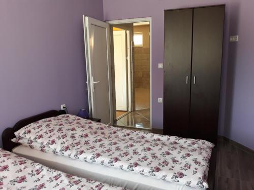 a bedroom with a bed and a closet and a mirror at Andi Apartman in Pačir