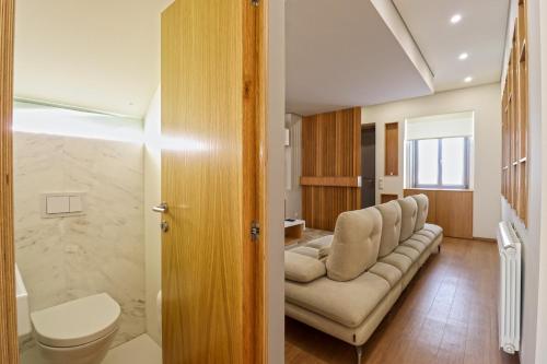 - un salon avec un canapé et des toilettes dans l'établissement Ribeira Riverhouse - City Centre Duplex with Terrace, à Viana do Castelo