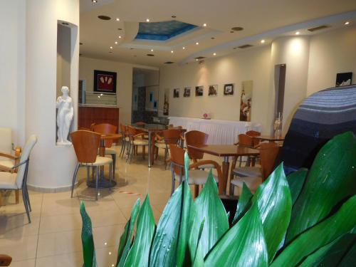 a restaurant with tables and chairs and a statue at Efstratios Hotel in Loutra Edipsou