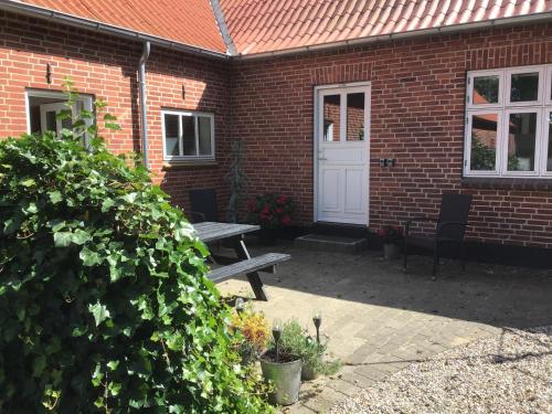a brick house with a picnic table and a white door at Varde Bed and Kitchen in Varde