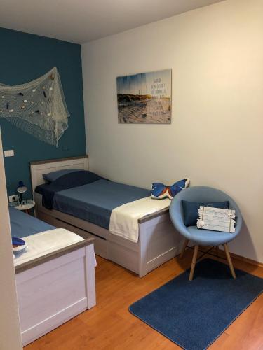 a bedroom with two beds and a blue chair at Villa Santoma Hill in Koper