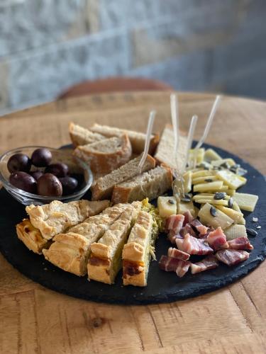 a plate of food with bread and other foods on a table at Villa Santoma Hill in Koper