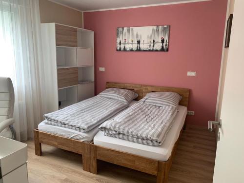 2 Betten in einem Schlafzimmer mit einer roten Wand in der Unterkunft Exklusives Wohnen am Stadtpark in Bad Driburg