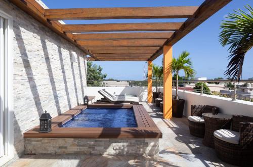 a patio with a swimming pool and a wooden pergola at Azura Boutique Hotel in Tulum