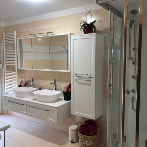 a bathroom with two sinks and a mirror at Villa Santoma Hill in Koper