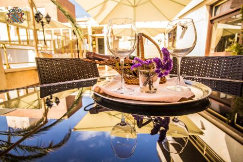 een tafel met twee wijnglazen en bloemen erop bij Hotel Victoria in Segur de Calafell