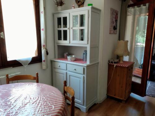 une armoire blanche dans une pièce avec une table dans l'établissement Résidence Peyresourde, à Luchon